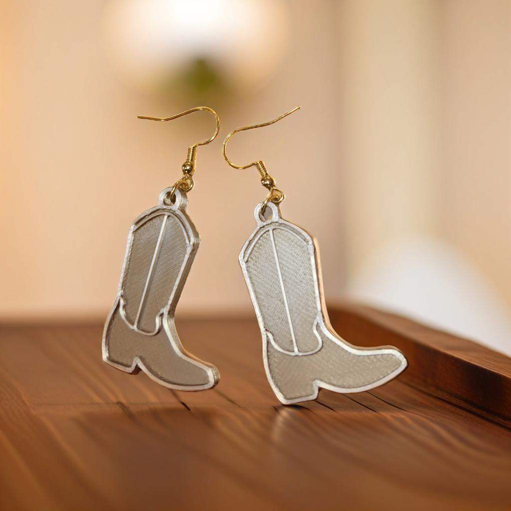 Cowboy boot earrings pair on wooden surface
